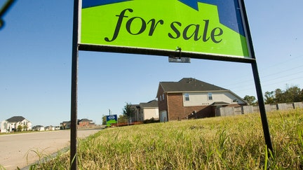 A for sale sign sits in front of a vacant lot near completed homes in a Missouri subdivision. - Fox Business News