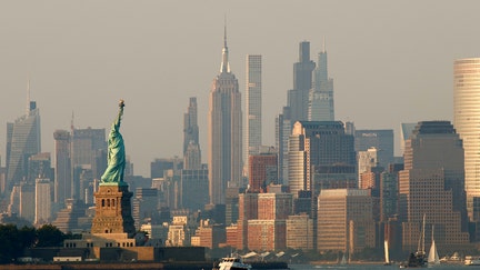 The sun sets on the Statue of Liberty and the Empire State Building in New York City on July 28, 2025, as seen from Bayonne, New Jersey. - Fox Business News