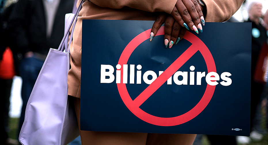 Woman holding anti-billionaires sign