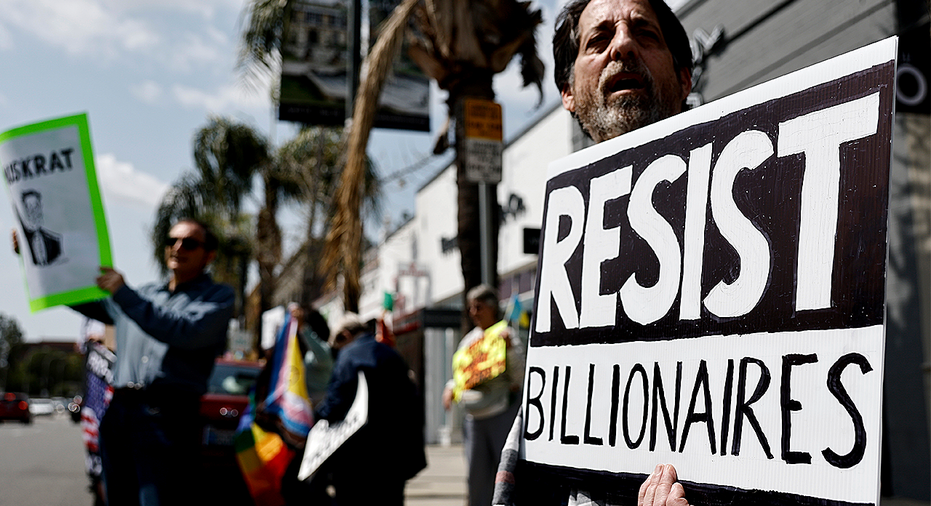 Person holding up 'resist billionaires' sign