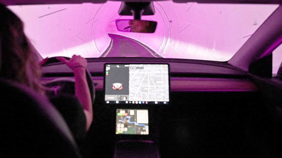An electric car moves through an underground transit tunnel system during a major technology trade show.