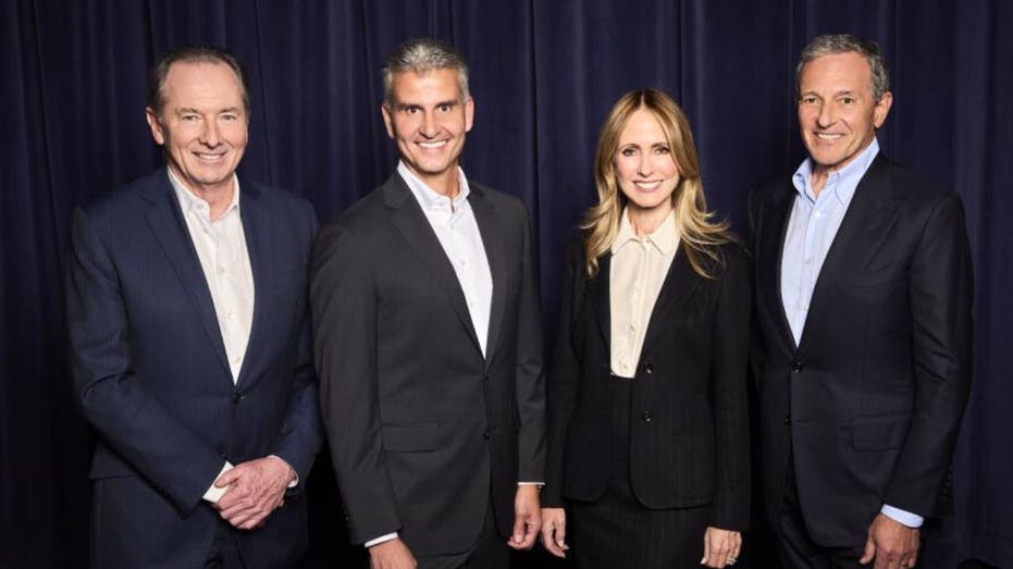 James Gorman, Josh D’Amaro, Dana Walden and Bob Iger stand together in business attire during a Disney leadership announcement.