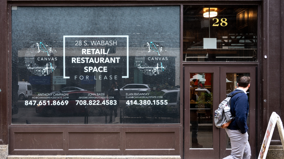 A man walks by an empty Chicago building up for a rent.