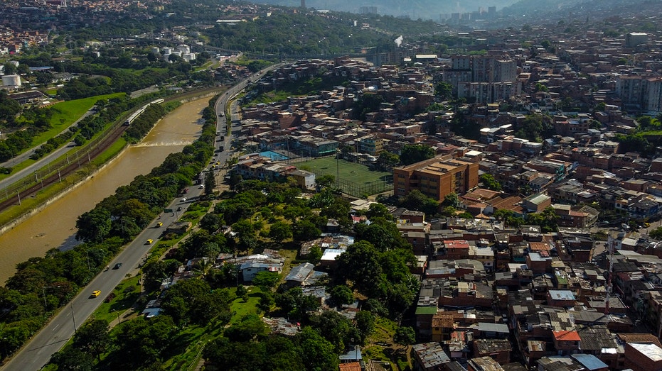 Aerial view of a neighborhood in medellin, colombia, with many buildings and a river