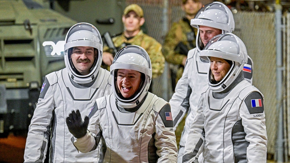 NASA's SpaceX Crew-12 crew members wave as they prepare for launch