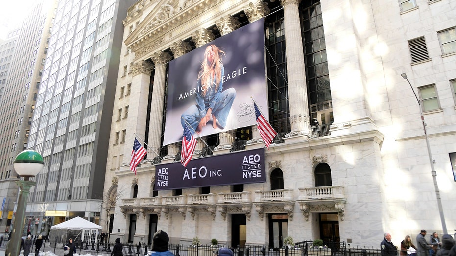 A large outdoor advertisement featuring actress Sydney Sweeney is displayed near a major financial landmark in Manhattan.