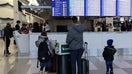 Travelers look at a flight information display board showing several flights cancelled due to weather at LaGuardia Airport in New York.  - Fox Business News