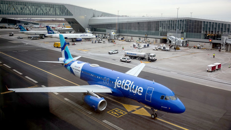 JetBlue aircraft parked at gates and taxiways at LaGuardia Airport as a winter storm approaches New York City.