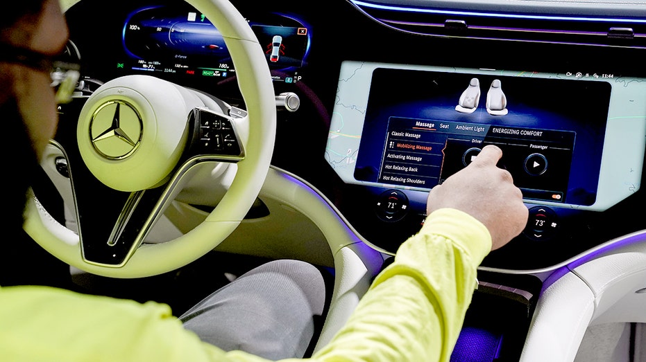 A person sits inside a Mercedes-Benz EQS.