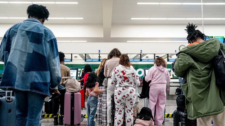 Passengers at a Frontier Airlines counter.