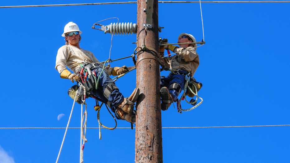 Men are seen working on a power line in Houston, Texas.
