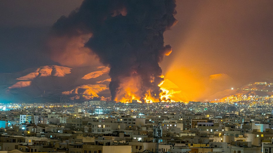 Thick smoke and flames rise from a burning oil depot in Tehran following reported airstrikes.