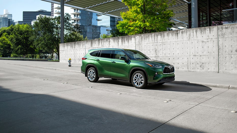 A green Toyota Highlander parked outside.