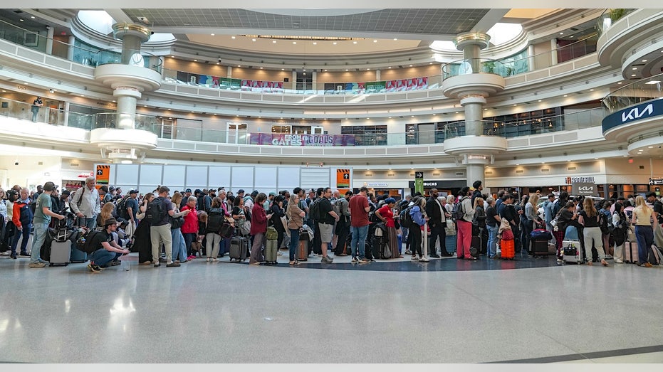 passenagers line up in long TSA lines at atlanta's airport