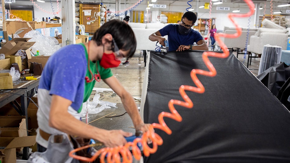 Furniture manufacturers work on a couch