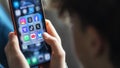 In this photo illustration a 14-year-old boy holds an iPhone screen displaying various social media and messaging apps. - Fox News