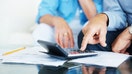 Closeup of a senior man's hand calculating bills at home - Fox Business News
