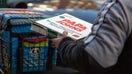 A delivery worker carries a Papa John's pizza outside a restaurant in New York. A message on its pizza boxes encouraging customers to tip delivery drivers fueled a debate online over tipping culture.  - Fox Business News