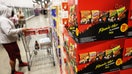Boxes of PepsiCo's Frito-Lay Flamin' Hot flavored snacks including Cheetos, Fritos, Doritos tortilla chips, and Funyuns are displayed alongside packaged foods for sale at a warehouse grocery store in Hawthorne, California on December 2, 2025.  - Fox Business News