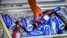 A hand reaches into a cooler box to retrieve a can and bottle of Budweiser Light beer at the Port Huron Sailing regatta in Michigan - Fox Business News