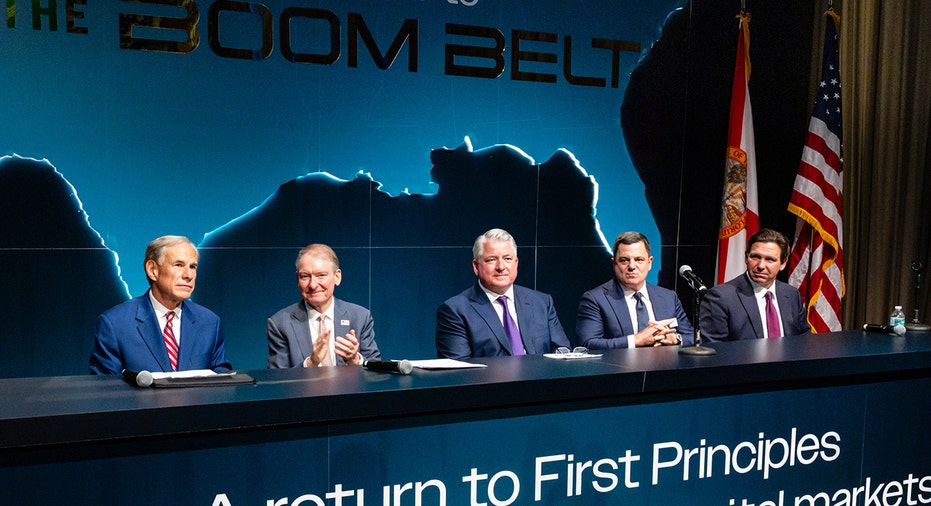 Business leaders sit at panel table