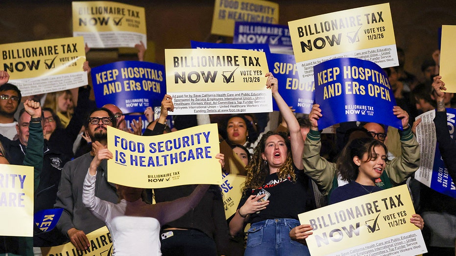 Protesters hold signs in support of billionaire tax