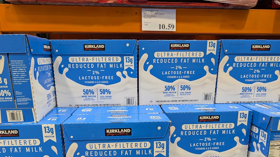 several blue boxes of kirkland signature milk sitting at costco shelves