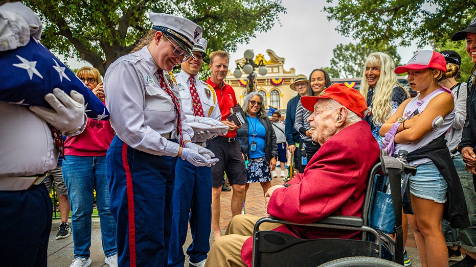 Charles Cram receives flag at Disneyland ceremony