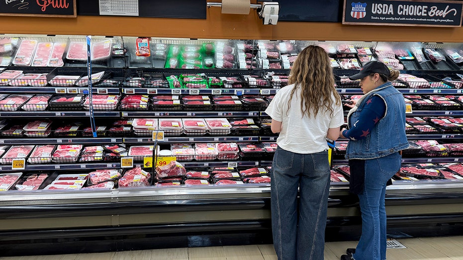 Customers shop for ground beef at grocery store