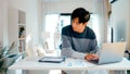 A younger person reviews bills on their desk and inputs them into a computer. - Fox News