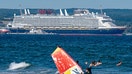 The cruise ship "Disney Adventure", built in the Wismar shipyard, is moored in the port of Mukran on the island of R&uuml;gen, while bathers and a windsurfer are in the water in the foreground. After around seven years of construction, one of the world's largest cruise ships starts its test voyages. The US shipping company Disney Cruise Line took over the ship from the insolvency estate and is having it built by the Meyer shipyard in Papenburg, Lower Saxony. The ship will be in service for the Disney Group in Southeast Asia from the end of 2025. - Fox Business News