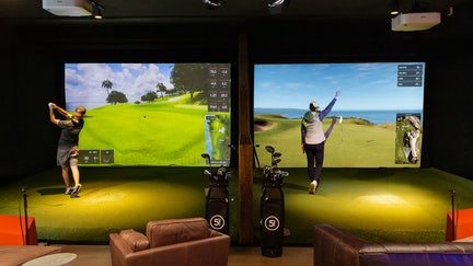 Golfers play a simulated round at a Five Iron location. - Fox Business News