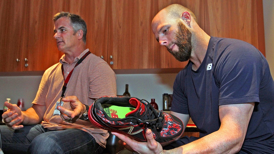Dustin Pedroia looks at cleat