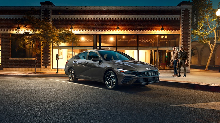 The 2026 Hyundai Elantra Hybrid is shown parked outside a storefront at night