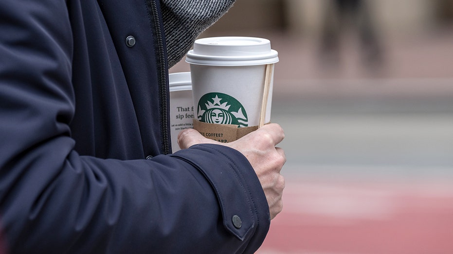 Person holding starbucks coffee cup