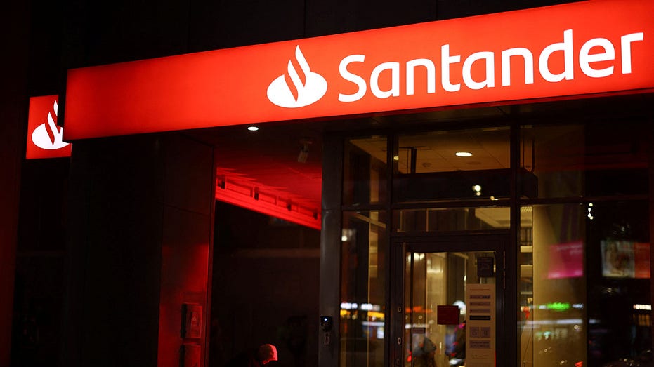 A Santander bank building at night.