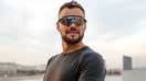 A man checks his smartwatch while wearing futuristic smart glasses in a stock photo illustrating wearable technology and connected devices. - Fox Business News