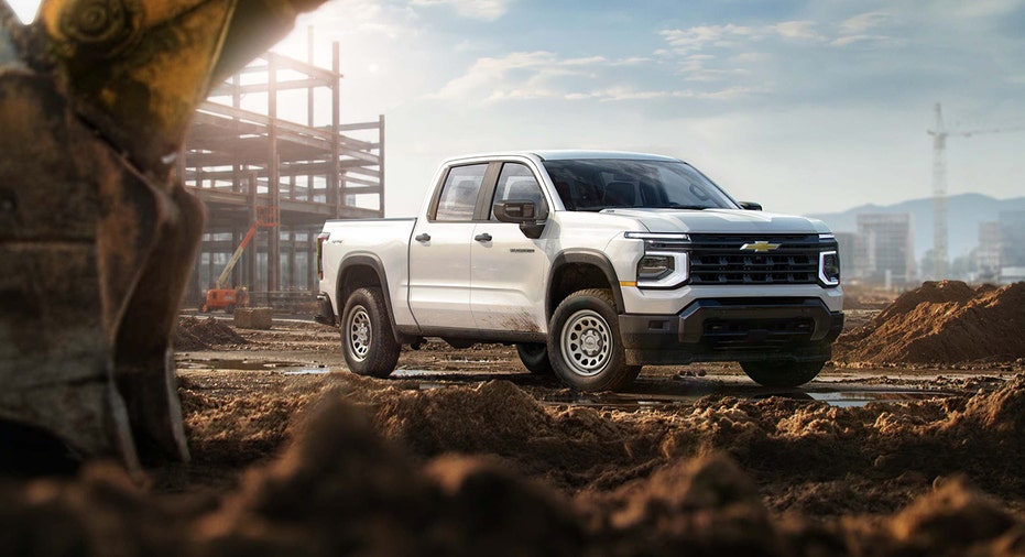 A 2027 Chevrolet Silverado 1500 Work Truck in Summit White is shown at a construction site.