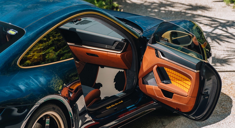 A Woody-inspired Porsche 911 Carrera T cabin features saddle-toned leather, denim-style fabric and an illuminated 