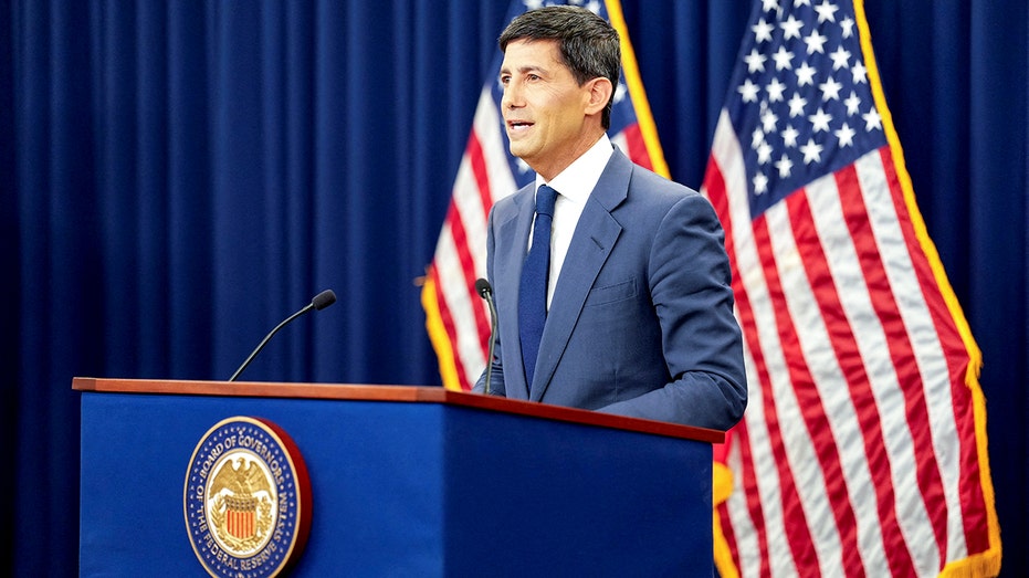 Kevin Warsh speaks from behind a podium.