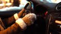 View from inside a car at night, showing a drivers gloved hands on the steering wheel with snow visible on the windshield, capturing the atmosphere of winter travel. - Fox News