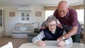 An older couple sits at a table in their house looking at an electronic device. - Fox News