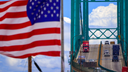 Cars are seen on a bridge with the American flag flying nearby.