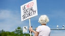 Woman holds sign at Social Security headquarters