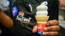 A Dairy Queen employee displays an ice cream cone for a photograph at a DQ Grill & Chill restaurant in Manhattan. - Fox Business News