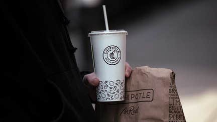 A customer holds a bag of food and a beverage cup outside a Chipotle restaurant in New York, US, on Friday, Jan. 12, 2024. - Fox Business News