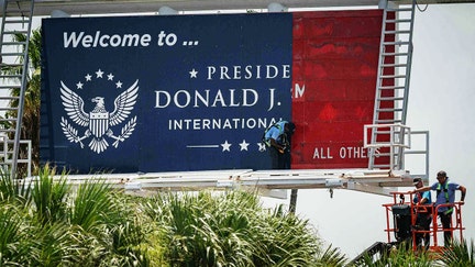 Workers install the new road entrance signage at Palm Beach International Airport in unincorporated Palm Beach County, Fla., on July 8, 2026. - Fox Business News