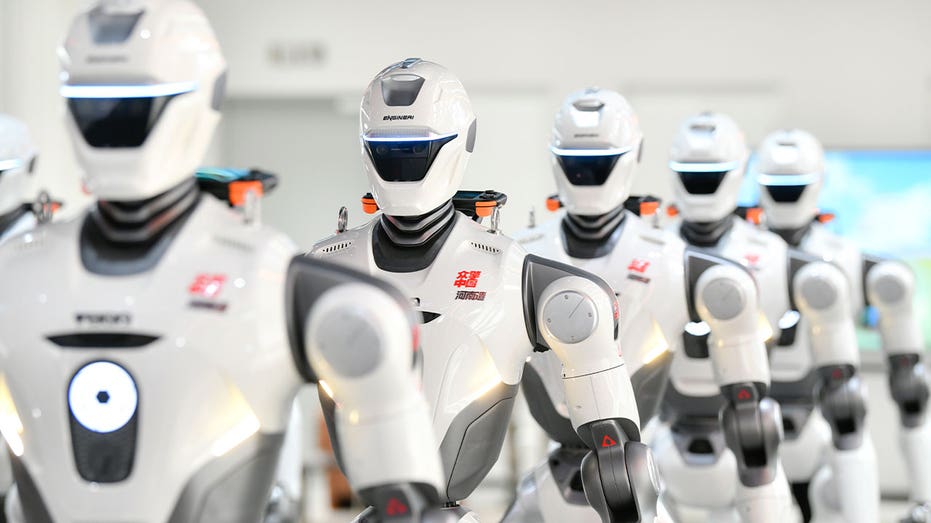Humanoid robots stand on display at a robotics exhibition
