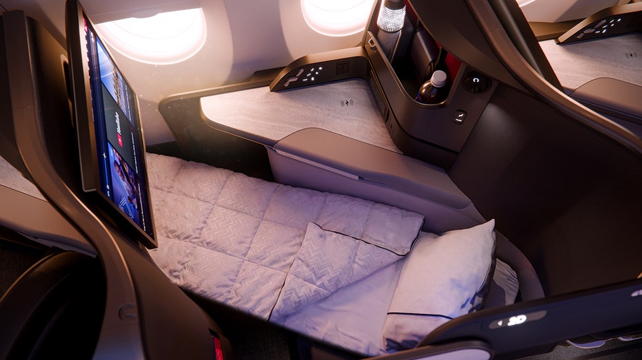 A Delta One lie-flat seat is seen inside an aircraft cabin.