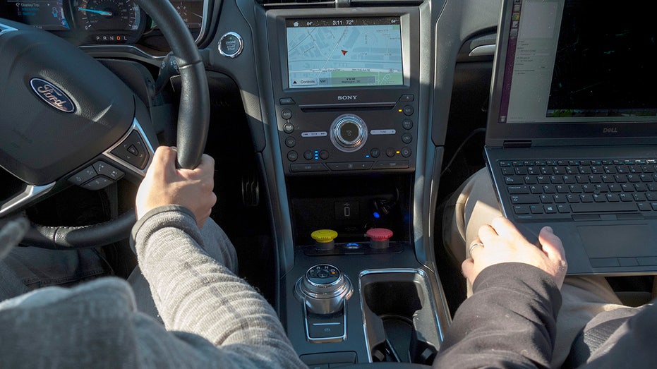 People driving a Ford with maps displayed